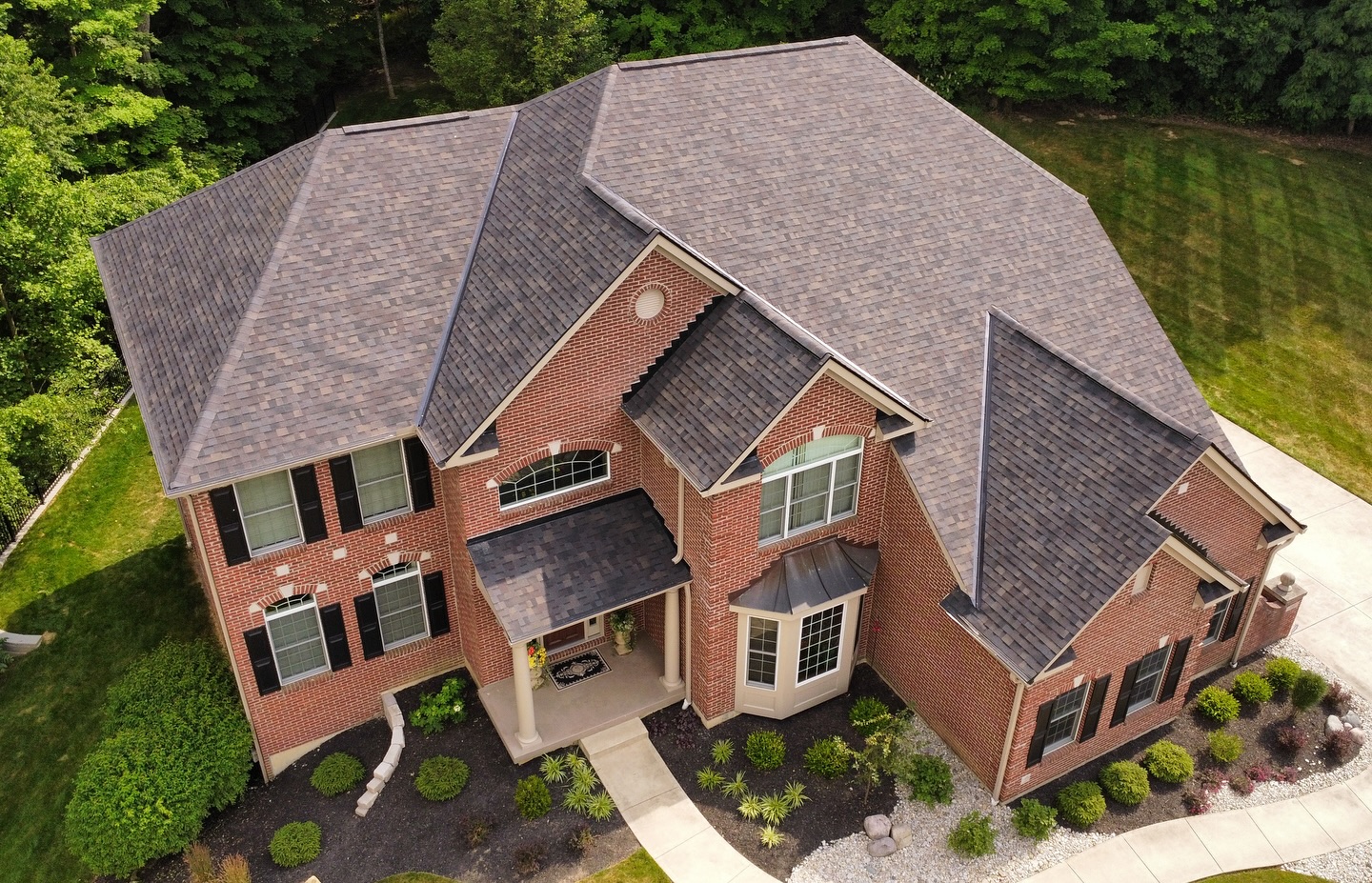 drone aerial brick two story home gray shingle roof front elevation